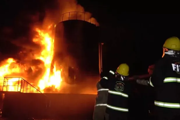 رجال إطفاء يحاولون التعامل مع حريق في مصنع أسمنت باجل بعد استهدافه بغارات إسرائيلية (إعلام حوثي)