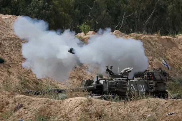 دبابة عسكرية إسرائيلية تُطلق النار باتجاه غزة (رويترز)