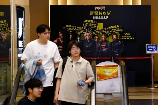 أشخاص يتجولون داخل دار سينما في بكين (رويترز)