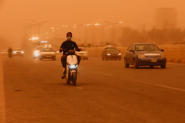 بالكاد يقود العراقيون سياراتهم بسبب انخفاض الرؤية خلال العواصف الترابية (رويترز)