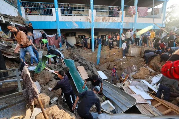 Gazze Şeridi'nin merkezindeki Bureyc mülteci kampında yerlerinden edilmiş Filistinlilerin barındığı UNRWA okuluna İsrail saldırısının yapıldığı alanda hayatta kalanları arıyor (AFP