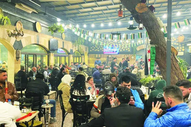 سوريون يتابعون كلمة أحمد الشرع في مقهى الروضة الدمشقي (الشرق الأوسط)