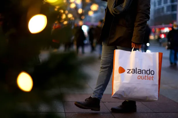 FILE PHOTO: A person with a shopping bag of Zalando outlet walks along Kurfuerstendamm shopping street looking for bargains in Berlin, Germany, December 3, 2022. REUTERS/Lisi Niesner/File Photo