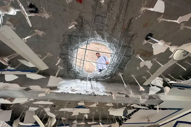 رجل يعاين الأضرار الناجمة عن هجمات صاروخية هندية طالت مبنى في مدينة كولتي بالشطر الباكستاني من كشمير أمس (إ.ب.أ)