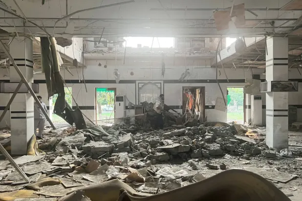 Bir adam Lahor yakınlarındaki Muridke'de bir camide meydana gelen hasarı inceliyor (Reuters)