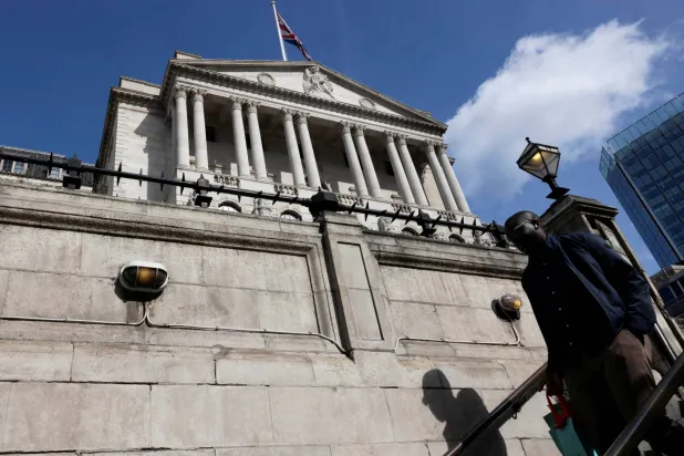 رجل ينزل الدرج بينما يظهر مبنى بنك إنجلترا في الخلفية في لندن (رويترز)