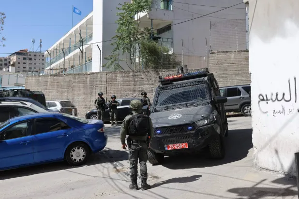 قوات أمن إسرائيلية أمام مدرسة تابعة لـ«أونروا» في مخيم «شعفاط» للاجئين بالقدس الشرقية (أ.ف.ب)