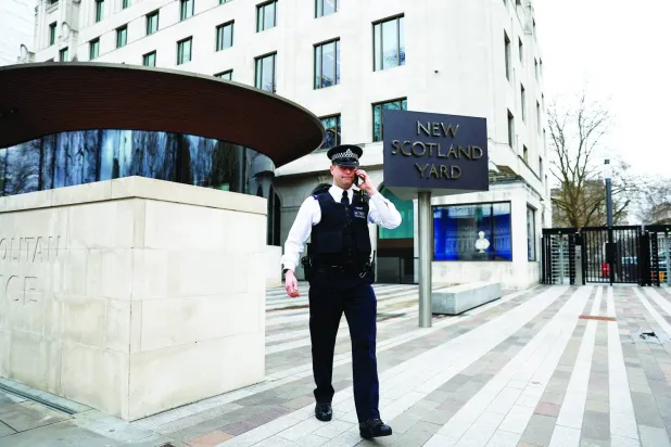 شرطي يسير خارج مبنى «نيو اسكوتلاند يارد» مقر شرطة العاصمة الحضرية بلندن (رويترز)