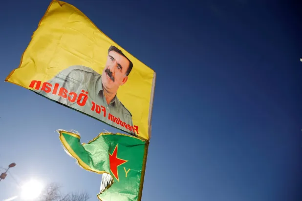 متظاهرون مؤيدون لـ«حزب العمال الكردستاني» يرفعون أعلاماً تحمل صور زعيم الحزب المسجون عبد الله أوجلان في ستراسبورغ بفرنسا (رويترز - أرشيفية)