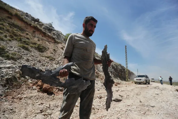 لبناني يحمل بقايا صواريخ إسرائيلية استهدفت الخميس محيط مدينة النبطية في جنوب لبنان (أ.ب)