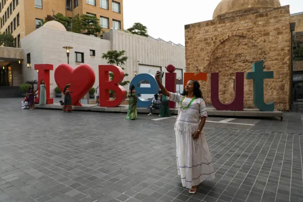 امرأة تلتقط صورة قرب لافتة «أنا أحب بيروت» في وسط العاصمة اللبنانية (رويترز)