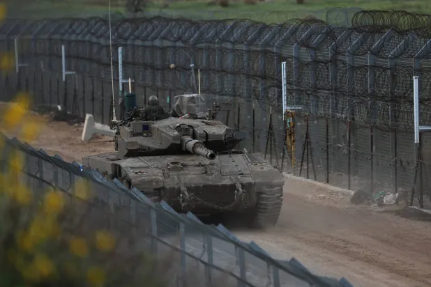 دبابة إسرائيلية يوم الخميس في المنطقة العازلة بين إسرائيل وسوريا قرب بلدة مجدل شمس في الجولان (إ.ب.أ)