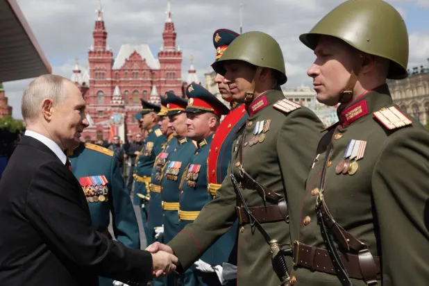 الرئيس الروسي فيلاديمير بوتين يصافح قادة عسكريين خلال العرض العسكري في ذكرى يوم النصر (أ.ف.ب)