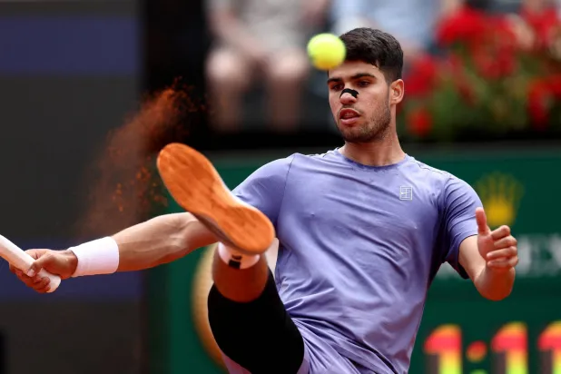 ألكاراس يحاول التصدي لكرة التنس بقدمه (رويترز)