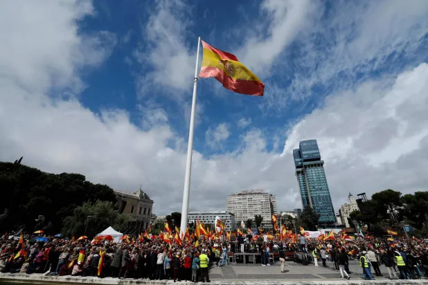 يحمل المتظاهرون أعلام إسبانيا خلال احتجاج مناهض للحكومة دعا إليه أنصار اليمين المتطرف في ساحة كولون في مدريد (أ.ف.ب)