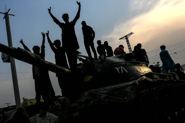 باكستانيون يحتفلون فوق دبابة بوقف إطلاق النار بين بلادهم والهند في مدينة ملتان (أ.ف.ب)