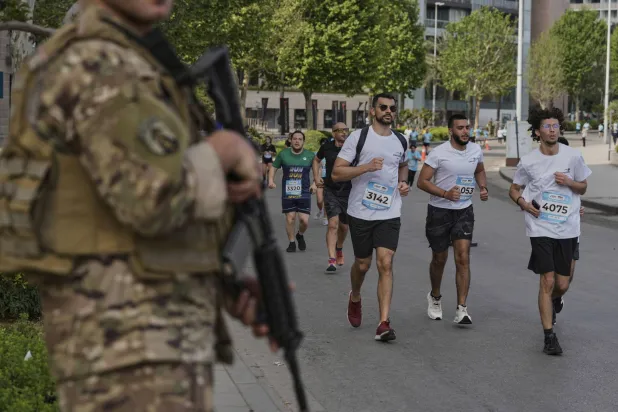 جندي لبناني يؤمّن متسابقين يشاركون في ماراثون في بيروت الأسبوع الماضي (أ.ب)
