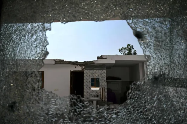 نافذة منزل محطمة في إقليم غامو الهندي نتيجة القصف عبر الحدود بين الهند وباكستان (أ.ف.ب)