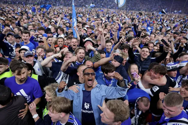 اقتحم بعض المشجعين أرض الملعب وأسقطوا لوحات إعلانية (إ.ب.أ)