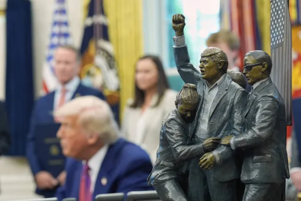 يظهر تمثال في المقدمة بينما يتحدث الرئيس دونالد ترمب مع الصحافيين في المكتب البيضاوي بالبيت الأبيض (أ.ب)