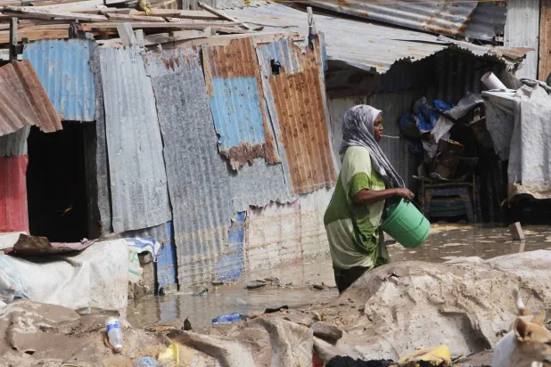 امرأة تقف أمام منزلها الذي غمرته المياه بعد هطول أمطار غزيرة  في مقديشو... السبت 10 مايو 2025 (أ.ب)