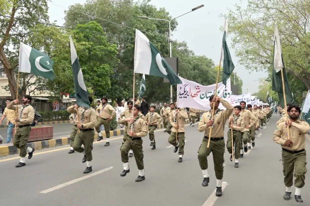 فتيان الكشافة يسيرون في شارع بلاهور بعد إعلان رئيس الوزراء الباكستاني شهباز شريف «يوم الامتنان» عقب وقف إطلاق النار بين الهند وباكستان (إ.ب.أ)