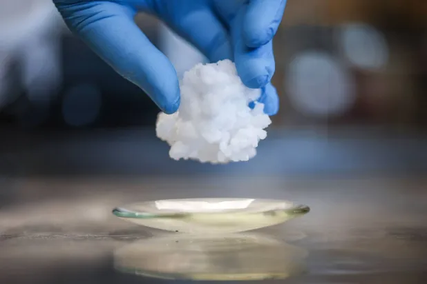 أحد الموظفين يحمل مادةً حراريةً باروكالية تستخدمها الشركة في تقنية تبريد الحالة الصلبة داخل مقرها الرئيسي بكمبردج (أ.ف.ب)