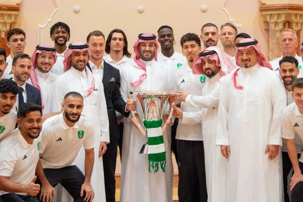 ولي العهد في لقطة تذكارية مع مسؤولي الرياضة السعودية ولاعبي النادي الأهلي (واس)