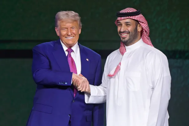 ولي العهد السعودي يصافح الرئيس الأميركي عقب نهاية مشاركتهما في منتدى الاستثمار السعودي الأميركي (إ.ب.أ)