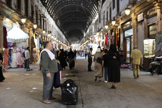 أشخاص يتسوّقون في سوق الحميدية في وسط دمشق بسوريا 14 مايو 2025 (إ.ب.أ)