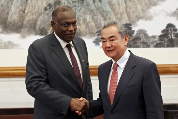 وزير الخارجية الصيني وانغ يي يصافح عمر صديق وزير الخارجية السوداني المعين حديثاً قبل اجتماعهما في دار ضيافة دياويوتاي في بكين 14 مايو 2025 (رويترز)
