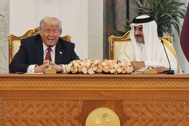 الرئيس الأميركي دونالد ترمب يتحدث مع أمير قطر الشيخ تميم بن حمد آل ثاني في الديوان الأميري بالدوحة خلال حفل التوقيع (أ.ب)