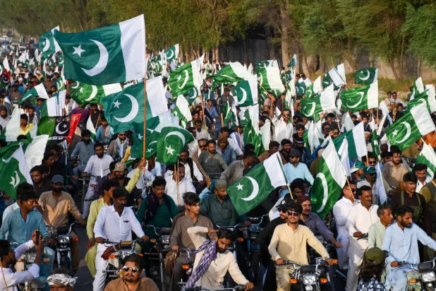 مواطنون يلوحون بأعلام باكستانية أثناء تجمعهم لدعم جيش بلادهم (رويترز)