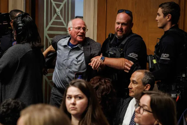 بن كوهين أحد مؤسسي شركة «بن آند جيريز» للمثلجات والناشط التقدمي لدى إخراجه بالقوة من جلسة مجلس الشيوخ أمس (أ.ف.ب)