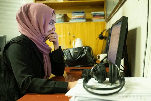 جامعية أفغانية تتابع أبحاثها في العاصمة كابل قبل خسارة وظيفتها (أ.ف.ب)