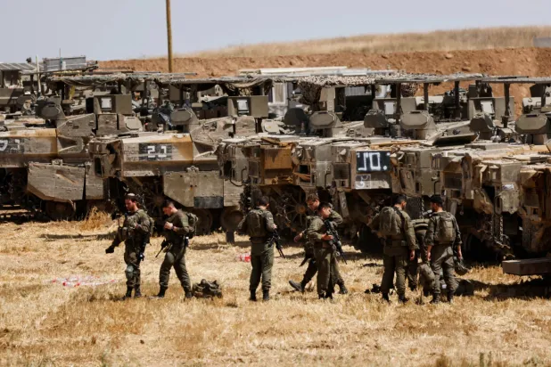 جنود إسرائيليون يتجمعون قرب الحدود بين إسرائيل وقطاع غزة 13 مايو الحالي (رويترز)