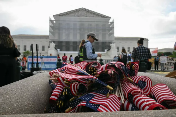 أعلام أميركية خلال احتجاج خارج المحكمة العليا في واشنطن على تحرك الرئيس دونالد ترمب لإنهاء حق المواطنة بالولادة (أ.ف.ب)