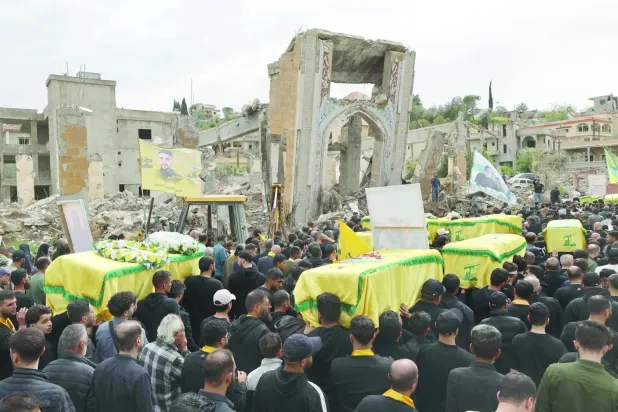 Lübnan'ın güneyindeki et-Taybe kasabasında bir milisin cenaze törenine katılan Hizbullah destekçileri, 6 Nisan 2025 (AFP)
