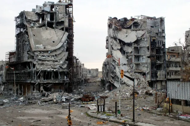 مبانٍ مدمرة تظهر في شارع خالٍ في حمص (أرشيفية - رويترز)