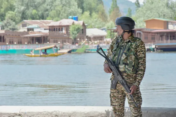 جندي هندي شبه عسكري يقف في حالة تأهب على ضفاف بحيرة دال عقب وقف إطلاق النار لإنهاء الصراع بين الجارتَيْن النوويتين الهند وباكستان في سريناغار (د.ب.أ)