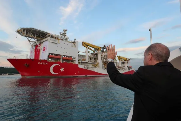 إردوغان يلوح لسفينة الحفر «فاتح» أثناء انطلاقها من إسطنبول باتجاه البحر الأسود (أرشيفية - رويترز)