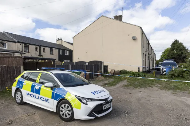 الشرطة البريطانية تطوّق منزلاً خلال اعتقال رجل إيراني في بلدة روتشديل قرب مانشستر الأحد (غيتي)