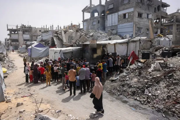 Gazze Şeridi'nin kuzeyindeki Cibaliye'de bir hayır kurumunun aşevinden sıcak yemek almak için sıraya giren Filistinliler (AFP)