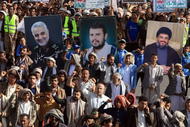حوثويون خلال حشد في صنعاء يرفعون صور زعيمهم وصورتَي قاسم سليماني وحسن نصر الله (إ.ب.أ)