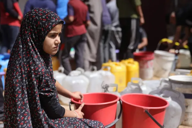 Gazze şehrinde su doldurmak için bekleyen bir kız çocuğu (AFP)