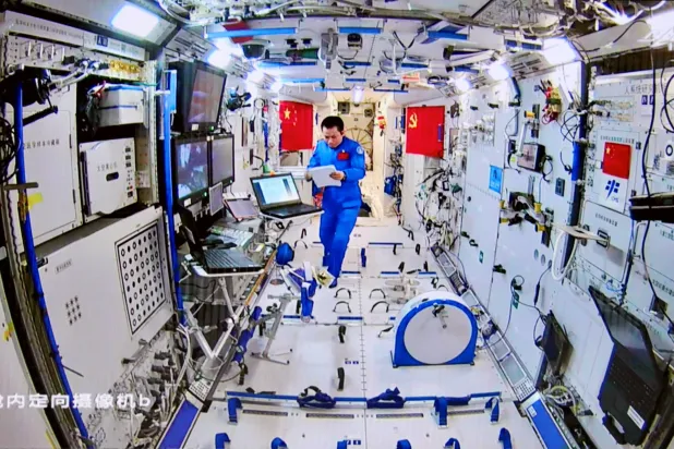 رائد فضاء يعمل داخل محطة الفضاء الصينية (رويترز)