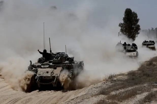 دبابات إسرائيلية تشق طريقها من الجانب الإسرائيلي نحو قطاع غزة أمس (رويترز)