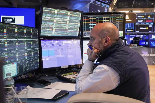متداول يراقب شاشة تعرض حركة الأسهم في بورصة نيويورك (أ.ب)