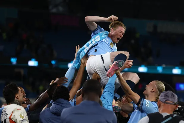 دي بروين في الهواء بأيادي زملائه (رويترز)