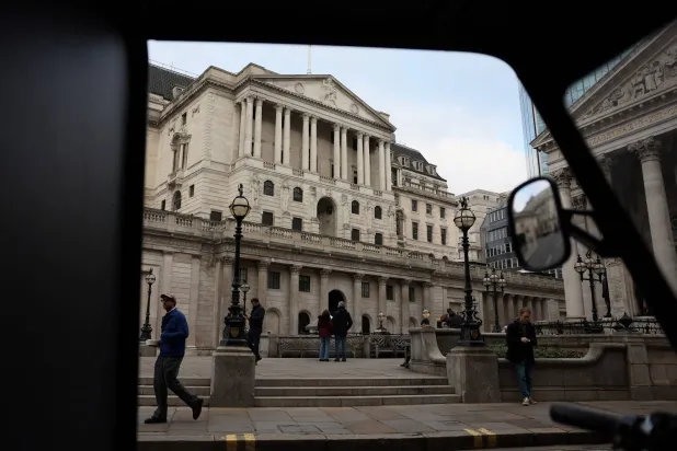 أشخاص يمرون أمام بنك إنجلترا في لندن (رويترز)